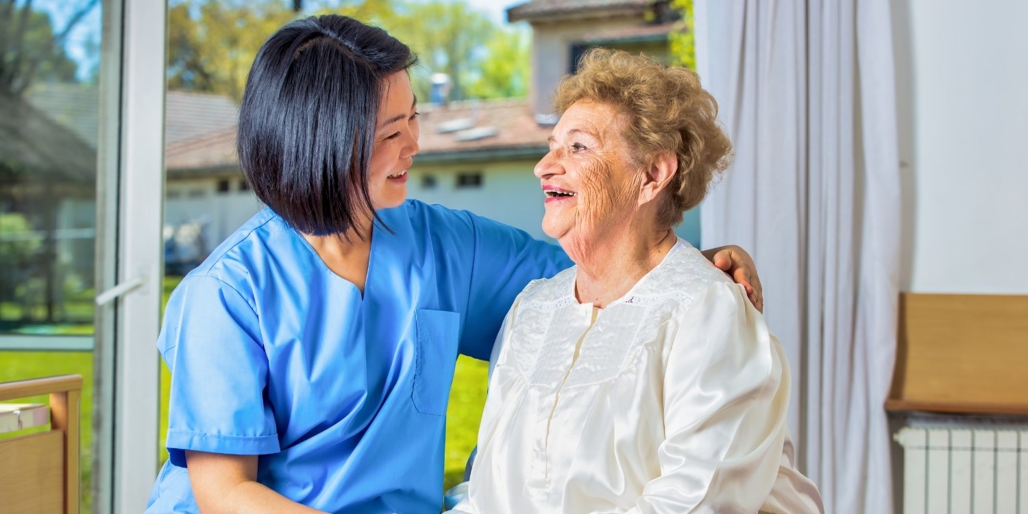Smiling home health clinician with an elderly patient.