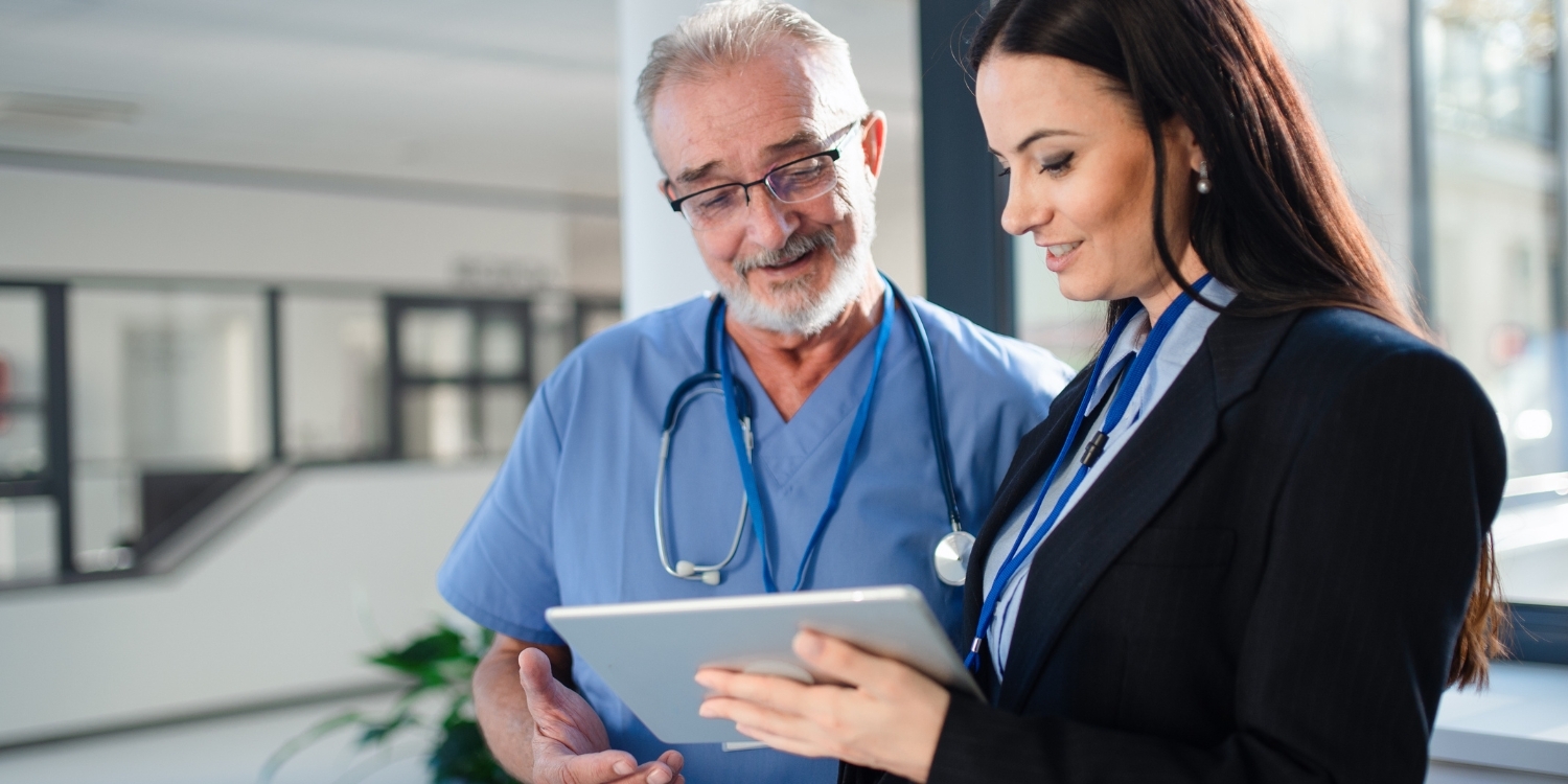 Clinician and consultant view a tablet.
