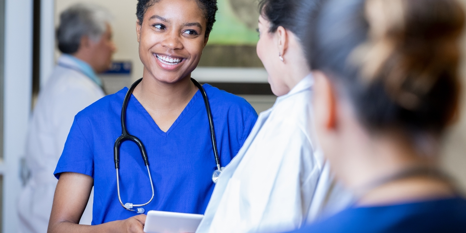 Clinicians smiling in conversation.