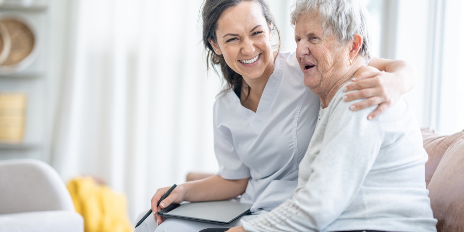 Smiling clinician with elderly patient.