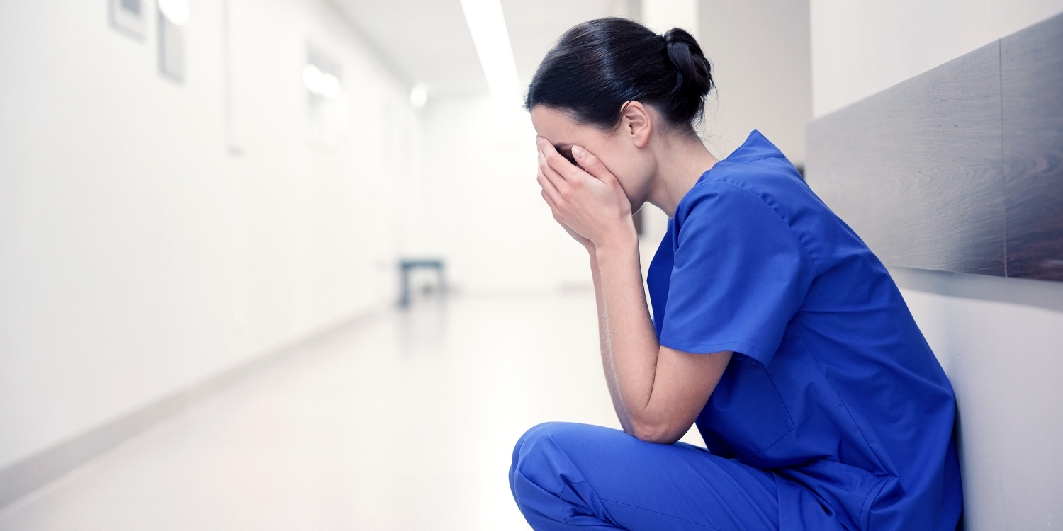 Emotional clinician with head in her hands.
