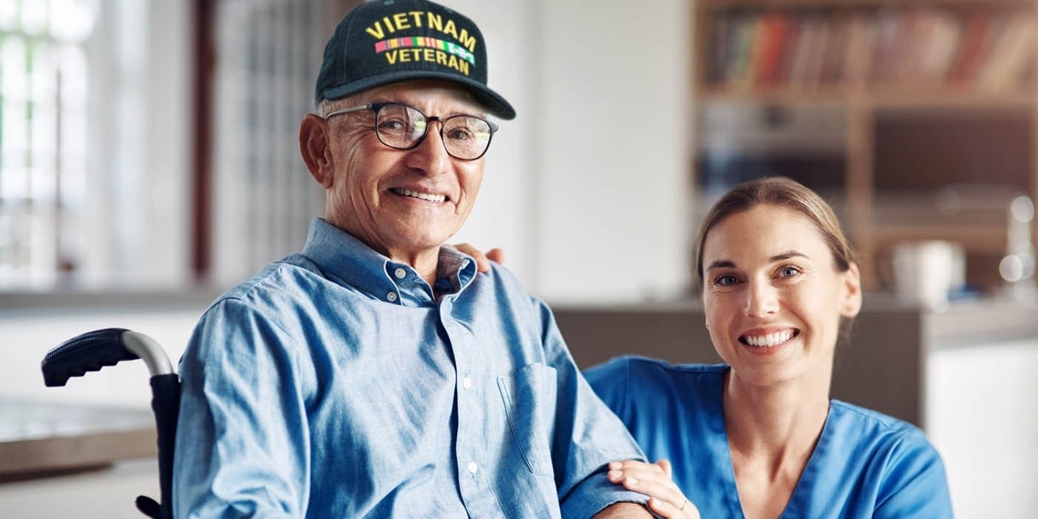 Smiling clinician caring for elderly veteran.