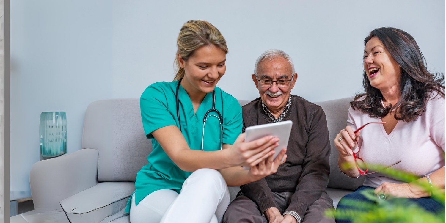Clinician showing tablet to elderly patient.