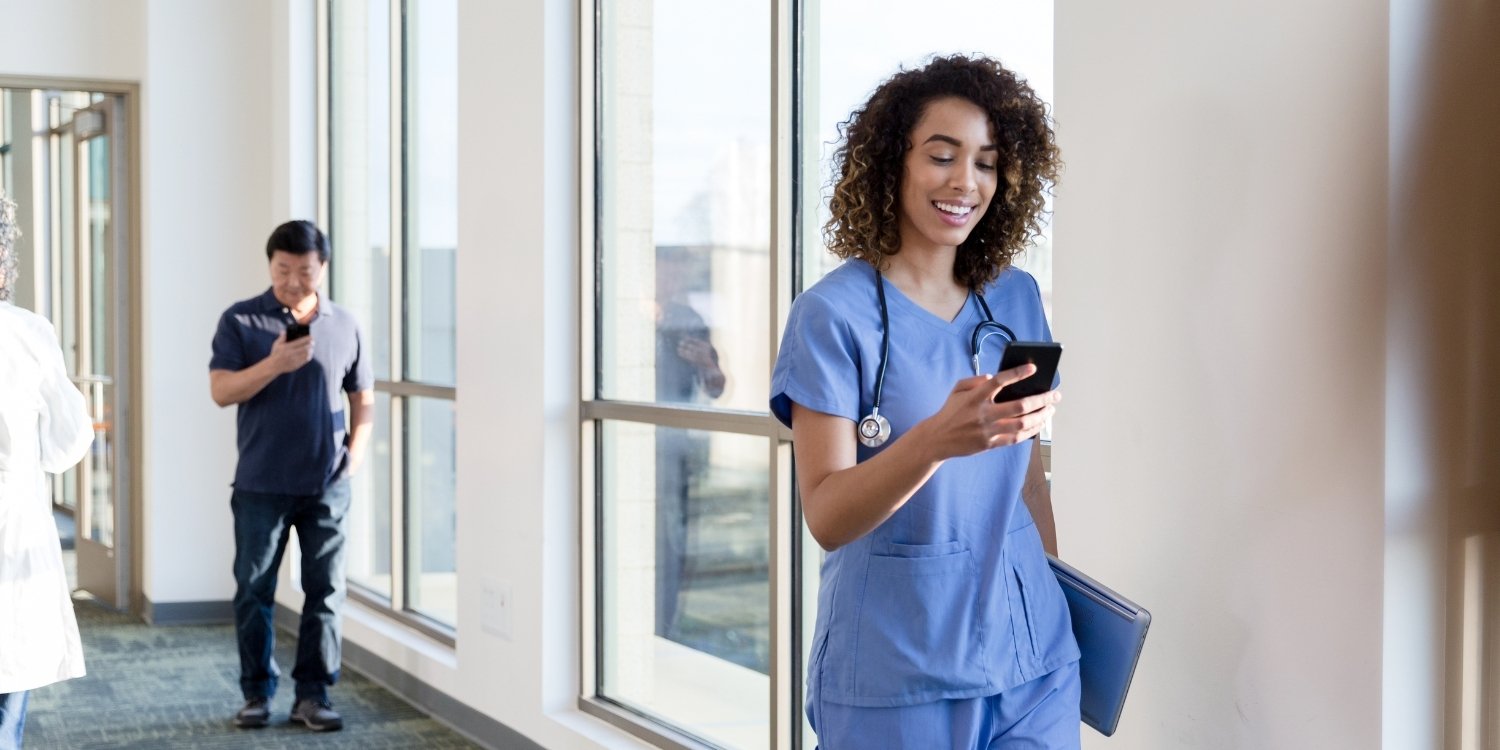 Caregiver smiling and looking at smartphone.