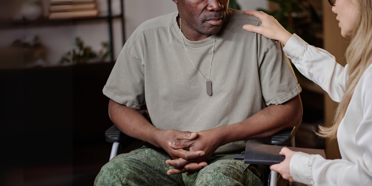 Veteran sitting in wheelchair next to caregiver